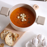 Chou Chou 8" Casserole filled with creamy soup, served with bread on a dining table