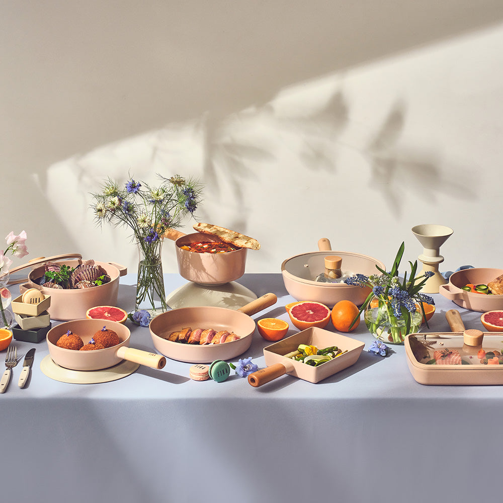 Lifestyle dining scene with FIKA Objet cookware collection arranged for multi-dish meal