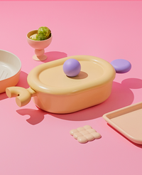 Top view of casserole with lid on a vibrant pink backdrop – playful and youthful design